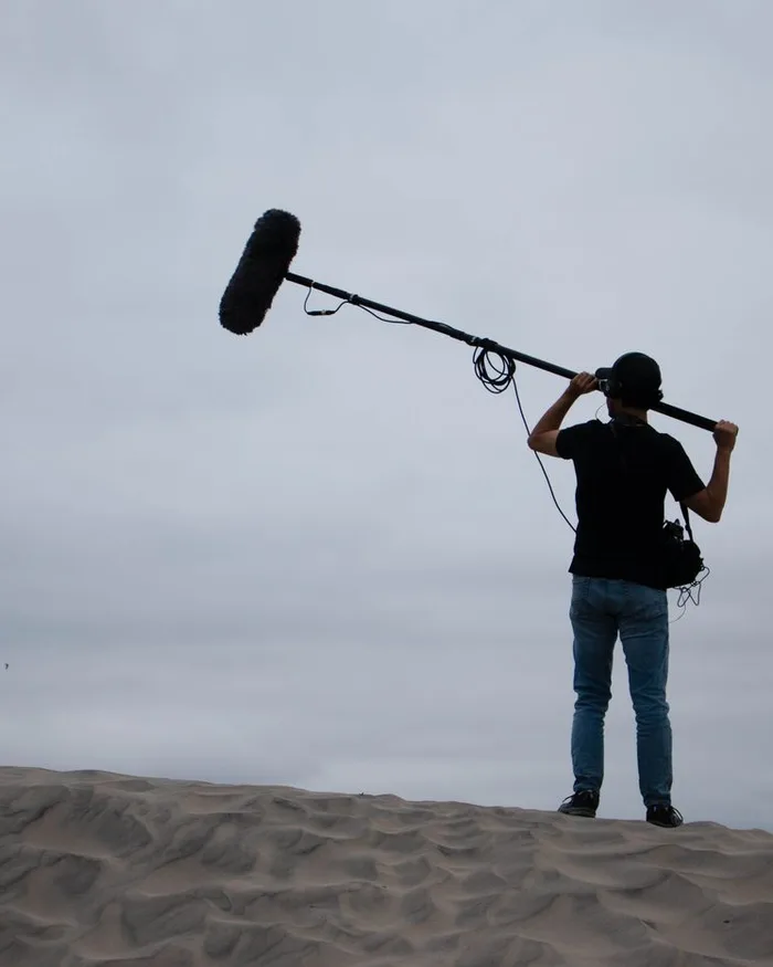 Ingénieur du son et sa perche, en tournage extérieur