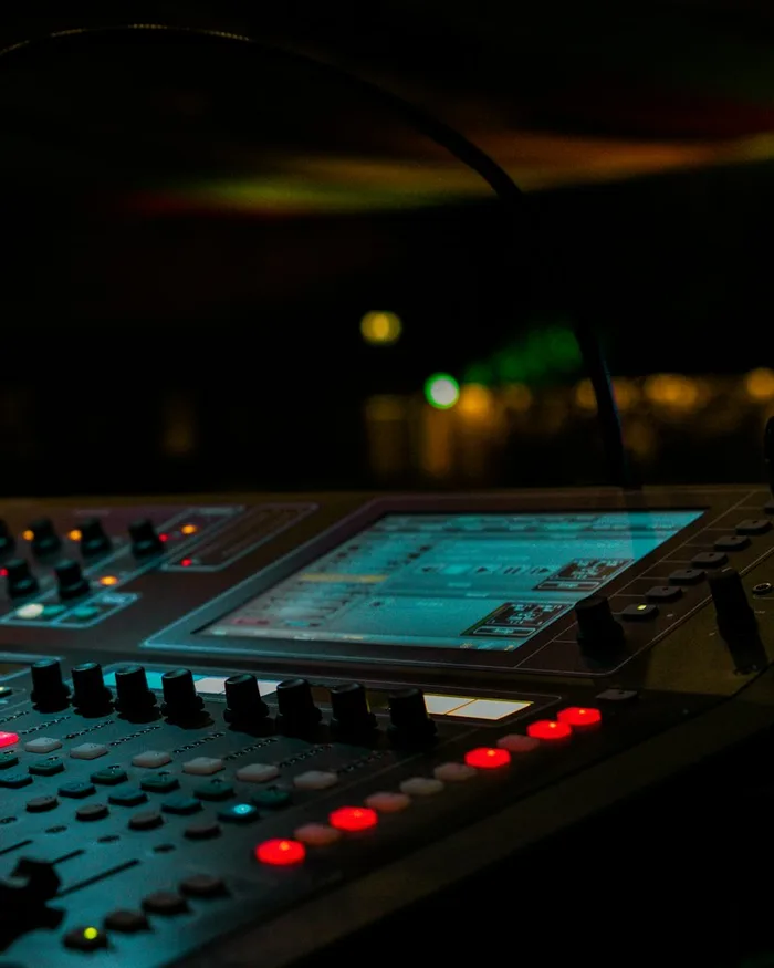 Console de mixage dans une salle plongée dans la pénombre